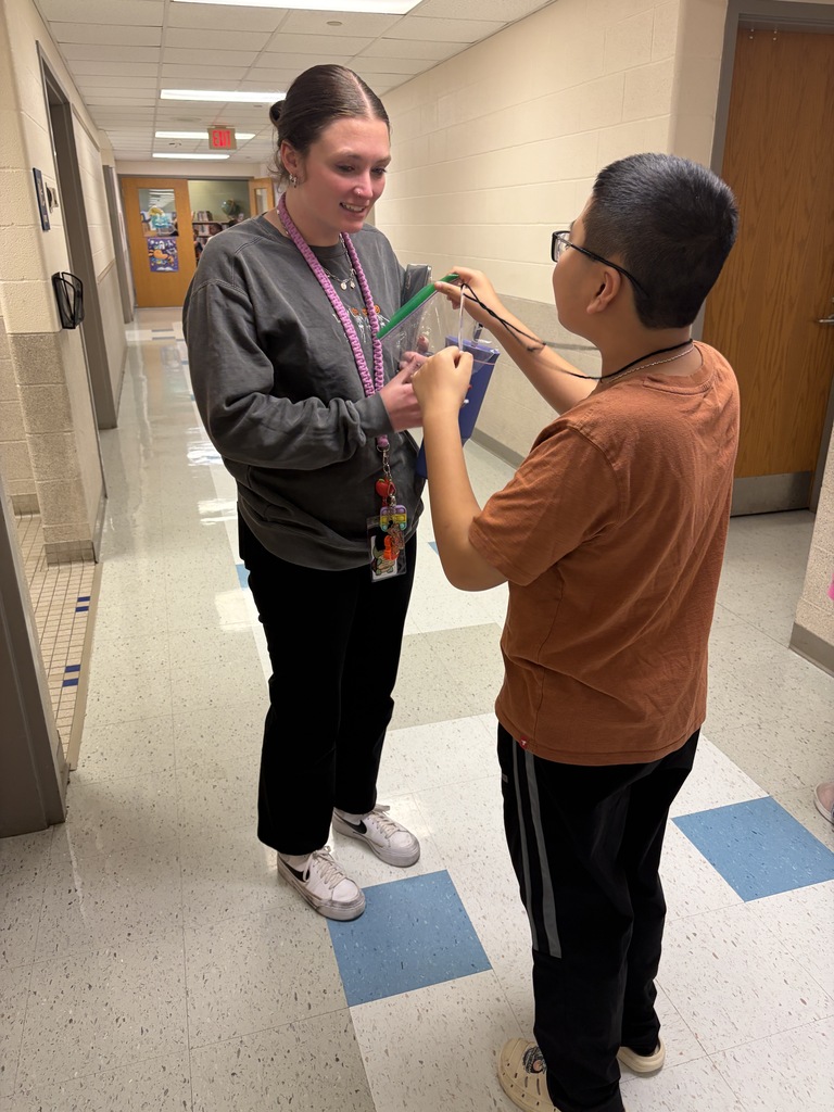 A student hands a staff member a bag of candy