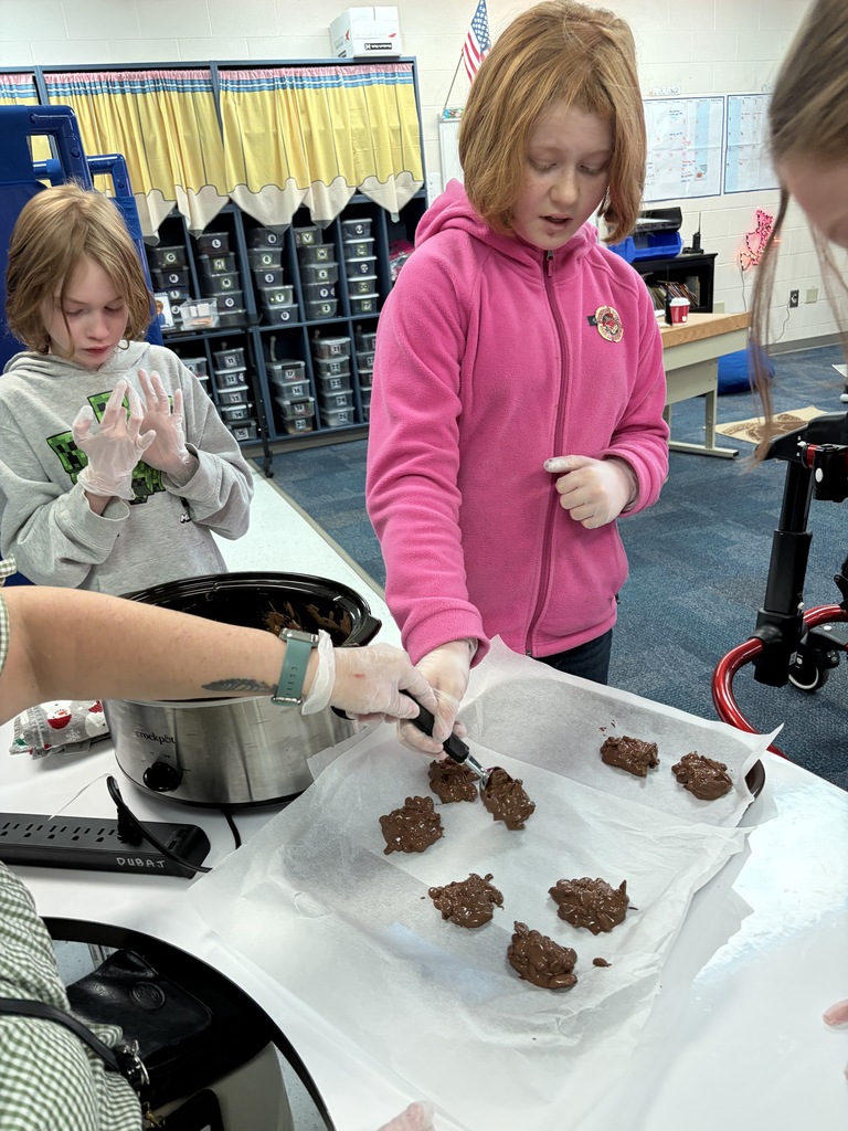 Two students help to portion out the candy on a tray