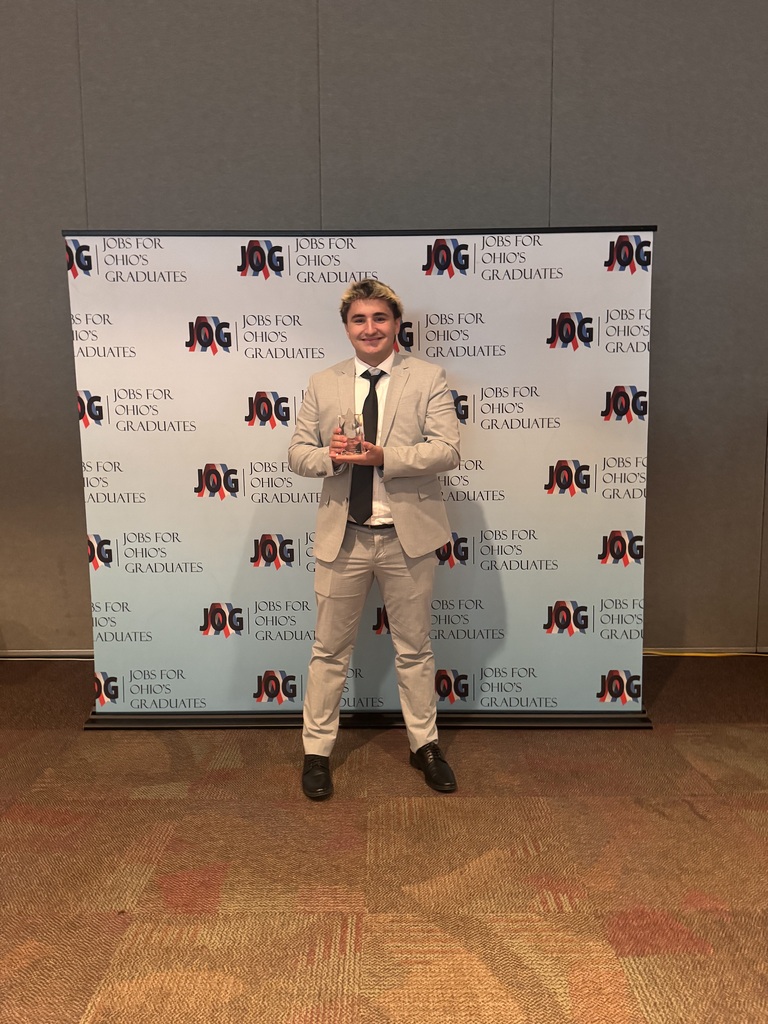 Mason Datz holds his award in front of a Jobs for Ohio Graduate back drop