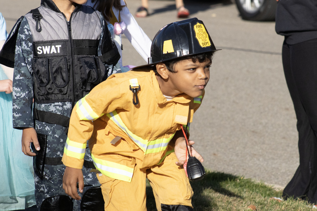 A student walks in the parade dressed as a firefighter