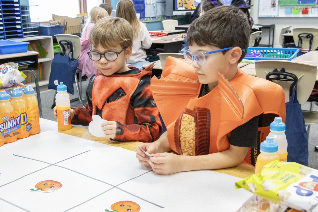 Two student dressed in costumes play tic tac toe