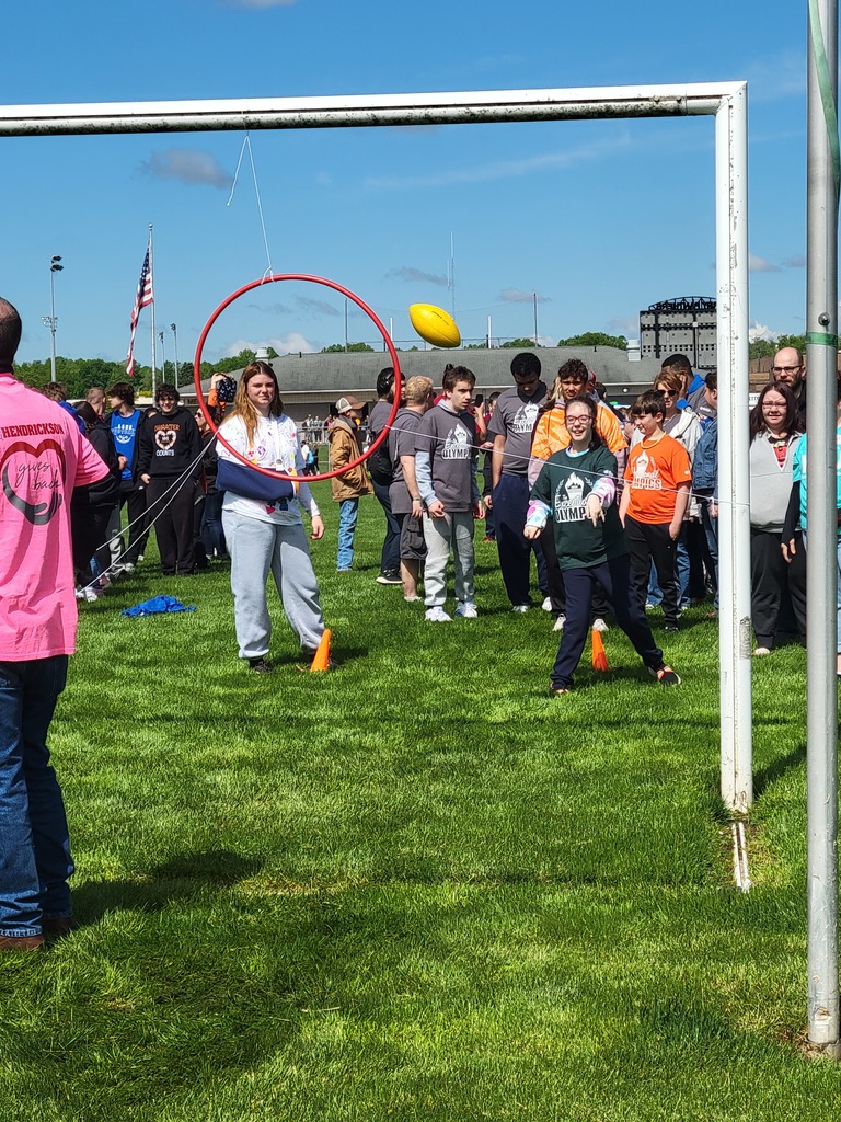 Students throwing a football at the exceptional olympics