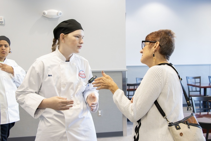 student talking to community member