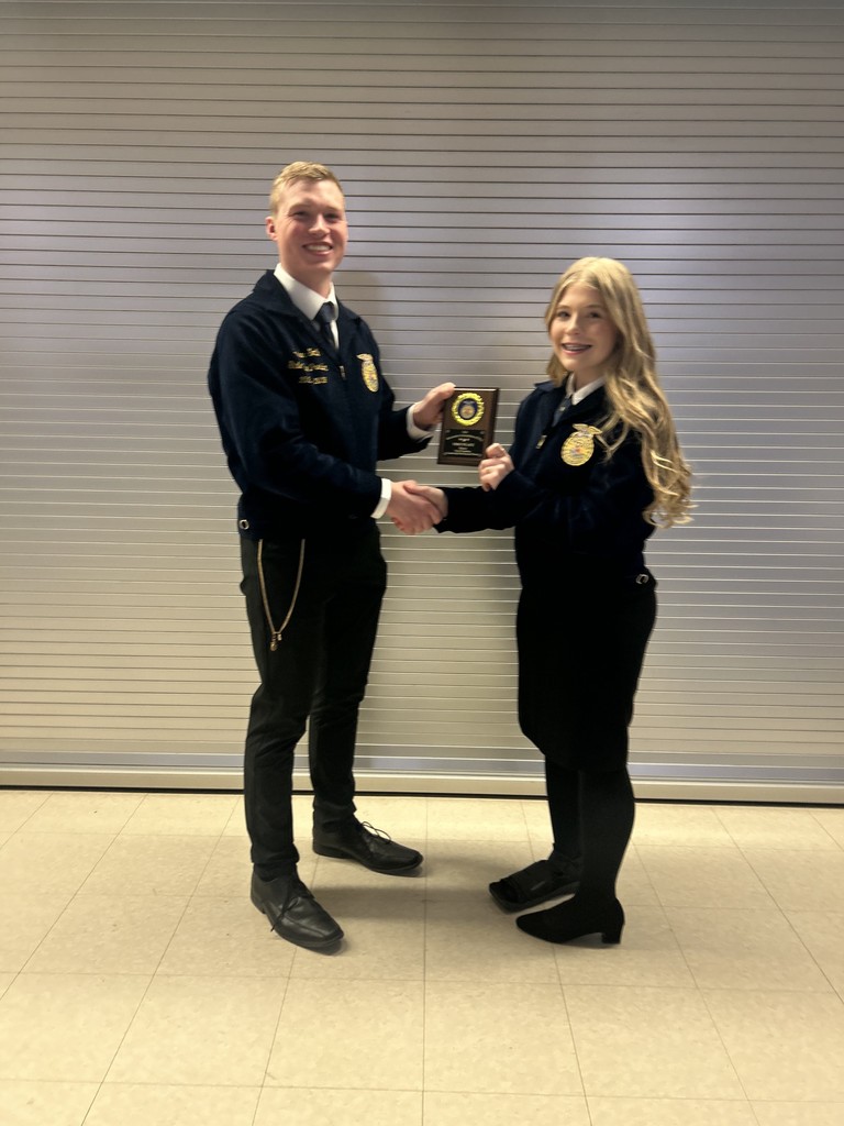 A moment of celebration as the State FFA Vice President presents the first-place plaque for Creed Speaking. This achievement reflects hours of practice and a deep commitment to the FFA values.