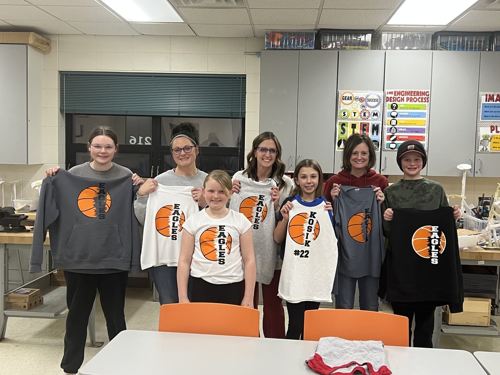 Many people holding custom made shirts that have a basketball and writing on them.