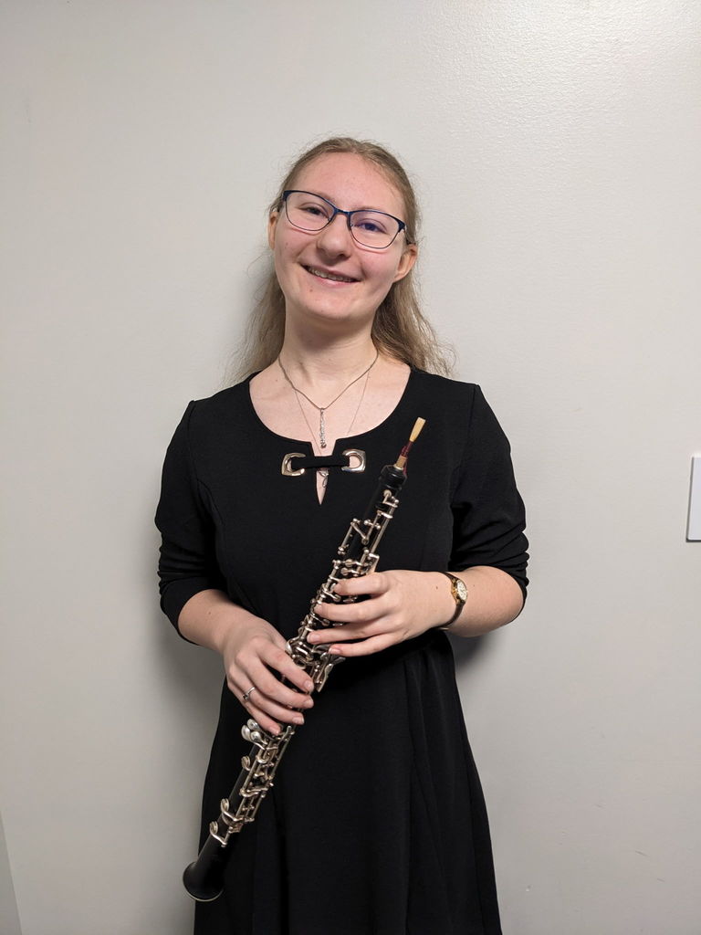 This is photo of Lorna Lisowski wearing a black dress holding her oboe.  