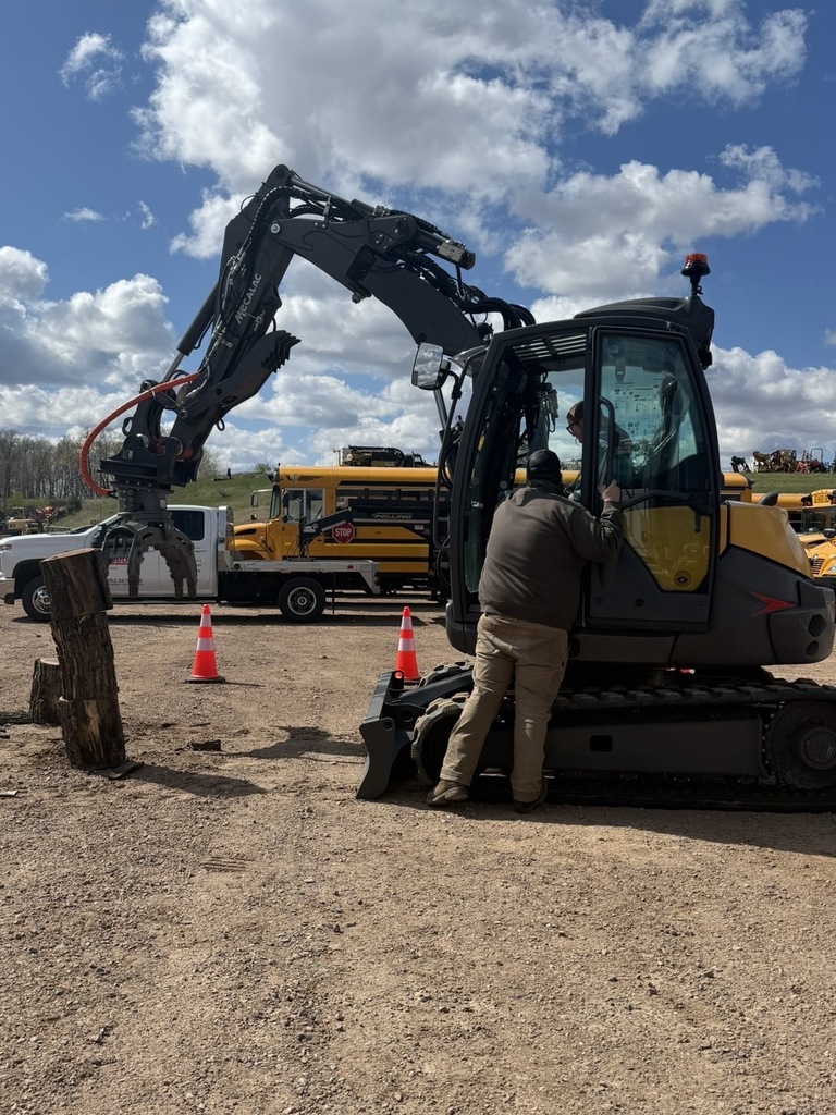 Sarah Burrow operating heavy machinery with Trevor Shultz