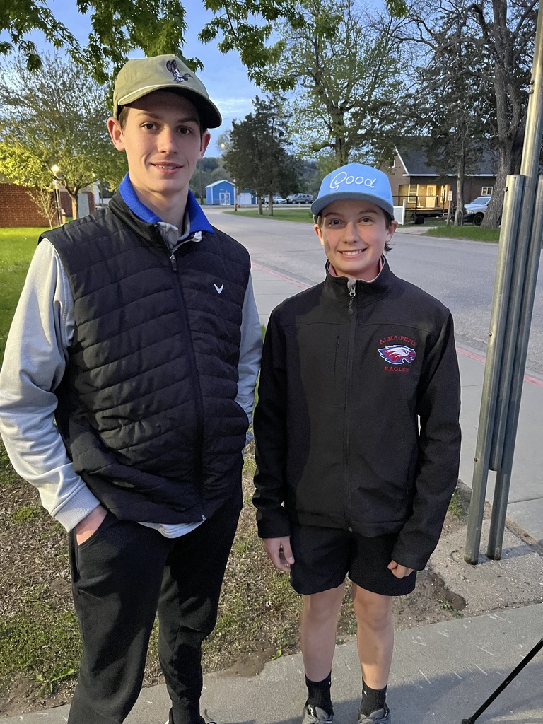 Two male golfers standing next to each other and smiling.
