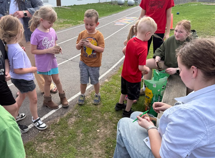 Students planting flowers in cups.
