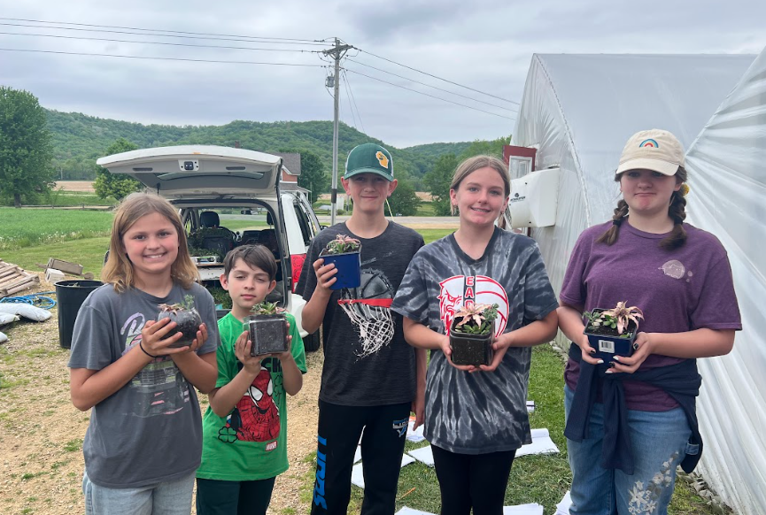 5 of the 6 graders holding their plants. 