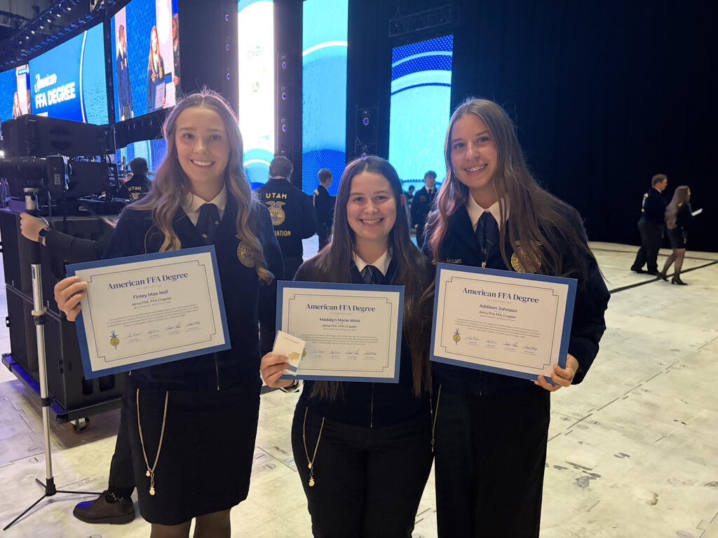 Finley, Madalyn, and Addison posing for a picture at the National FFA convention with their American FFA degrees.