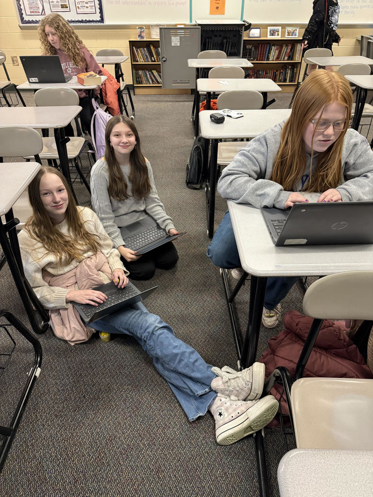 4 students work on middle school newspaper in classroom