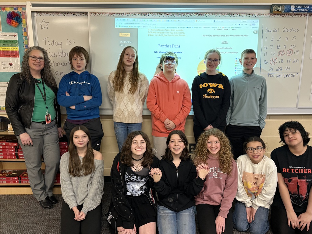 Some middle school newspaper students pose for a group picture with their teacher