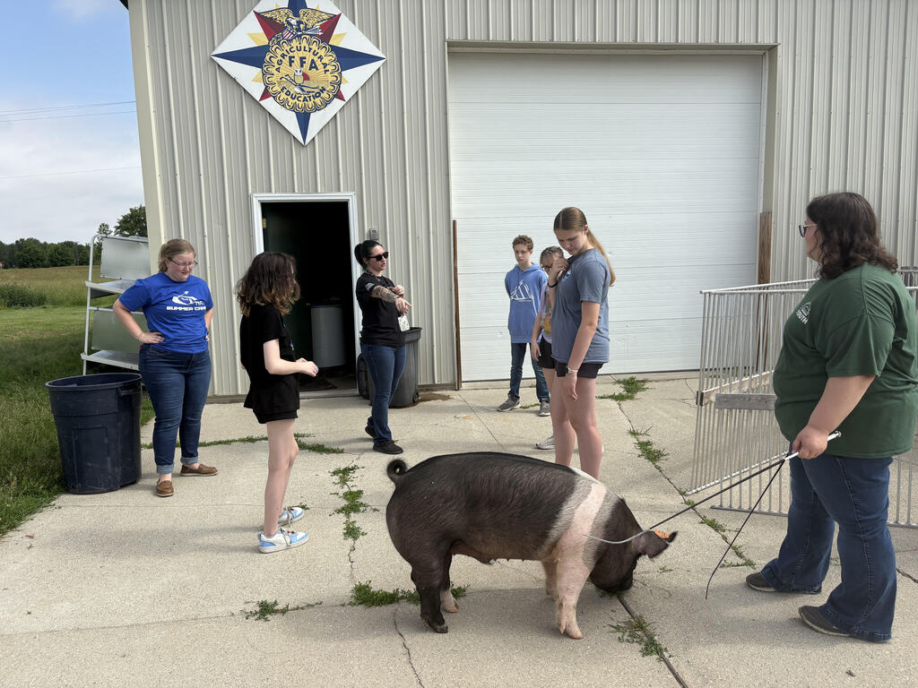 CTE summer camp students with pig