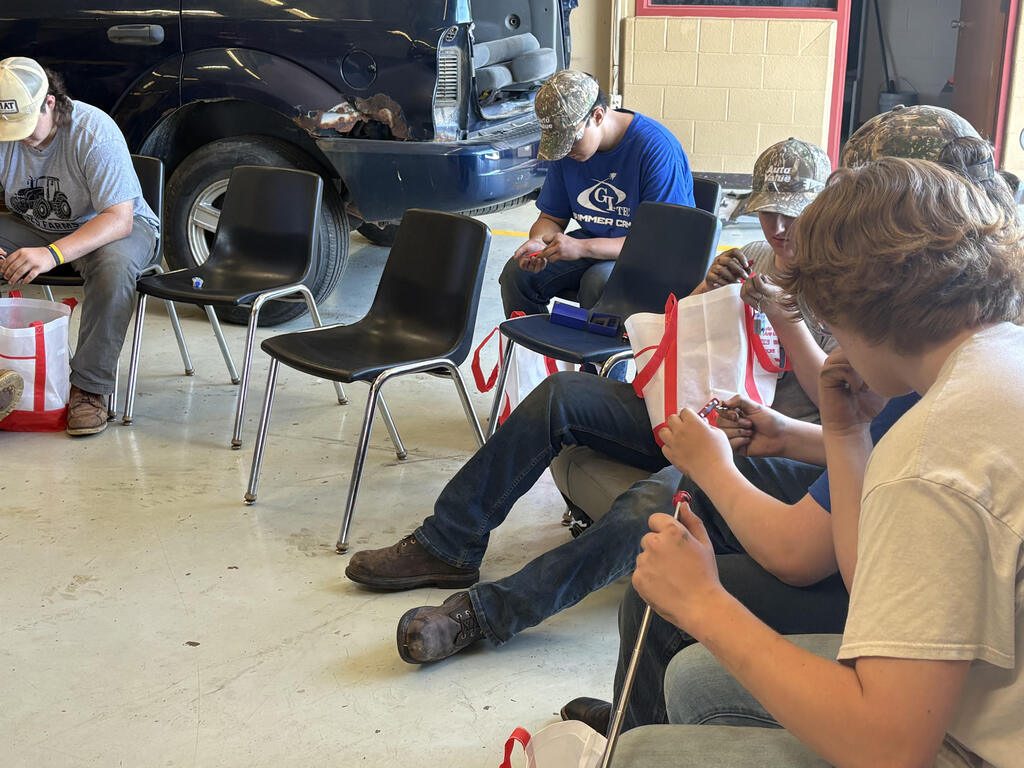 Automotive students looking at gift bag content