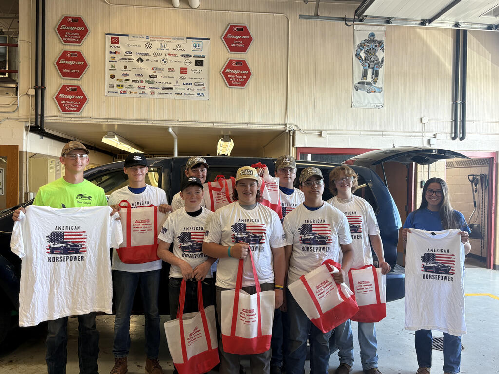 Automotive students looking at gift bag content