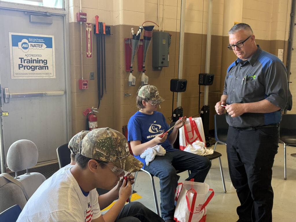 Automotive students looking at gift bag content