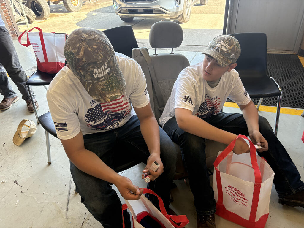 Automotive students looking at gift bag content