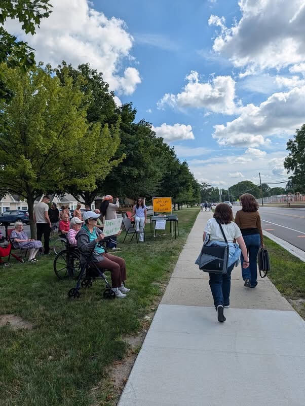 Arbor Grove residents and staff pass out snacks to APS students walking by