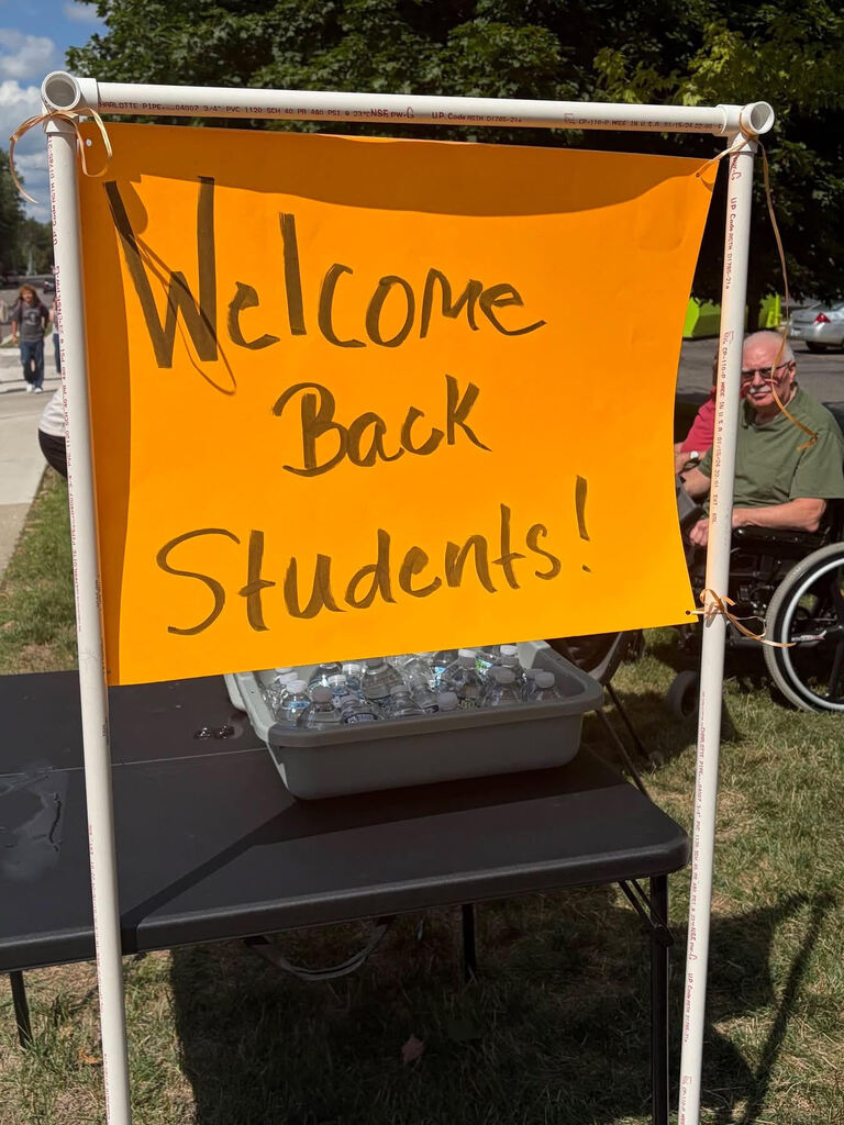 Neon orange sign welcoming APS students back to school