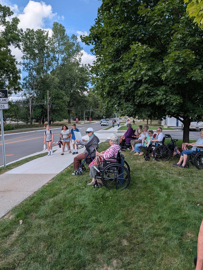 Arbor Grove residents and staff pass out snacks to APS students walking by