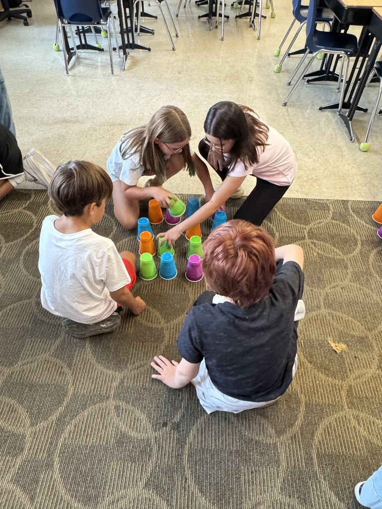 Four 5th graders use brightly colored cups to learn math in the classroom