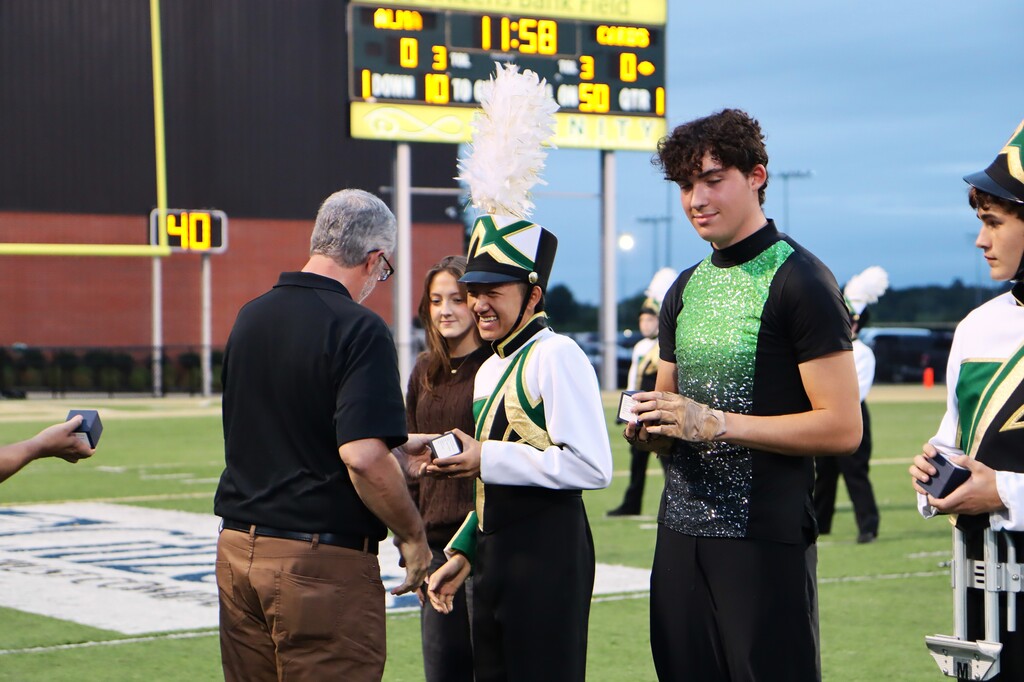 Current and former Alma High School Band directors presented championship rings to the students who made the achievement possible, including members who have since graduated.