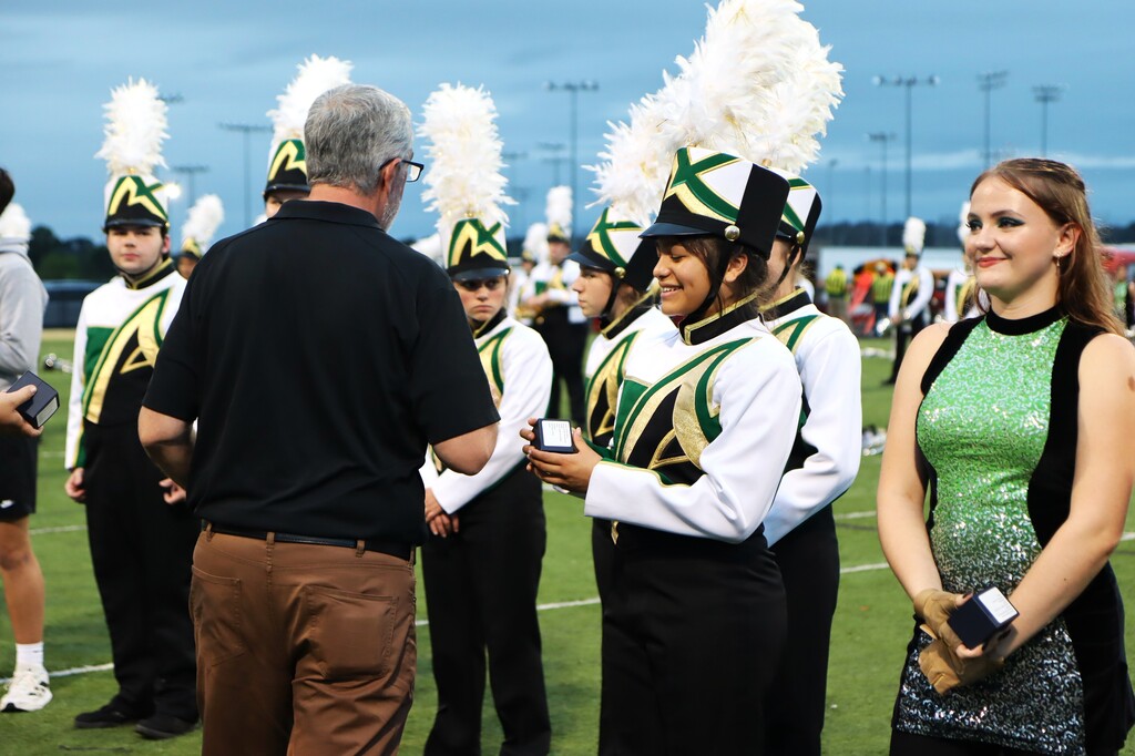 Current and former Alma High School Band directors presented championship rings to the students who made the achievement possible, including members who have since graduated.