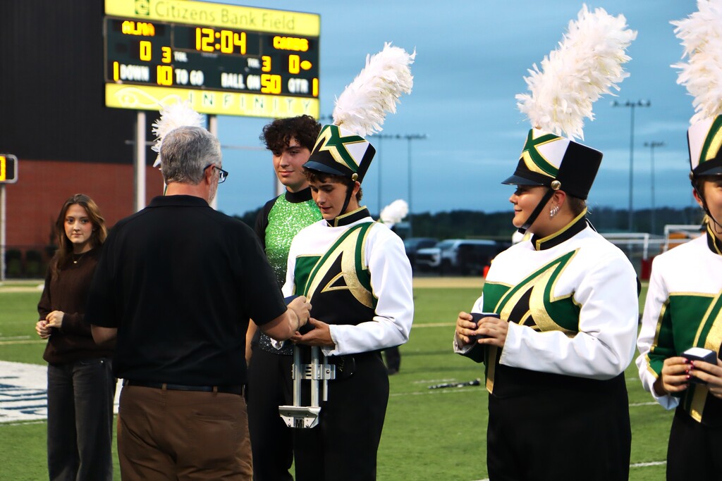 Current and former Alma High School Band directors presented championship rings to the students who made the achievement possible, including members who have since graduated.