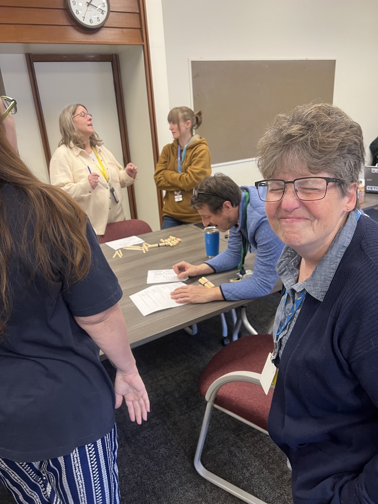 A teachers laughs as her group members practice the place value activity