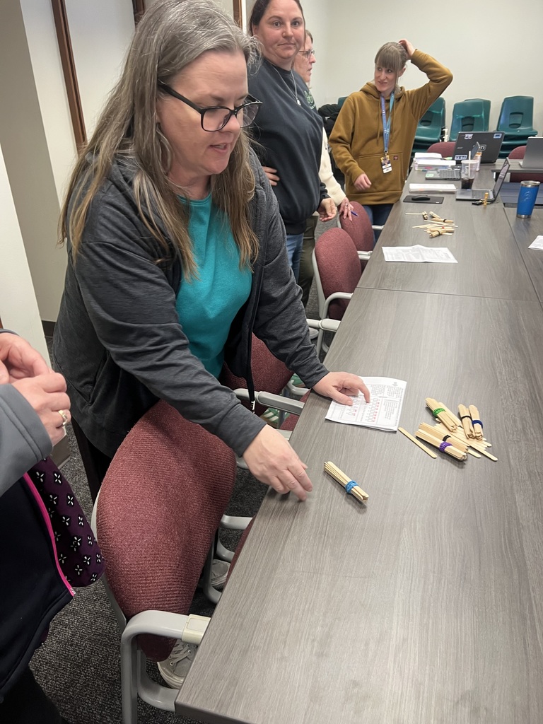 Teachers practice a place value activity with bundles of popsicle sticks