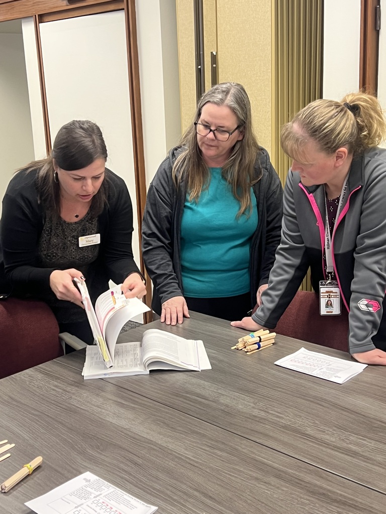 Teachers consulting their manual to check for deeper understanding as they practice a student activity.
