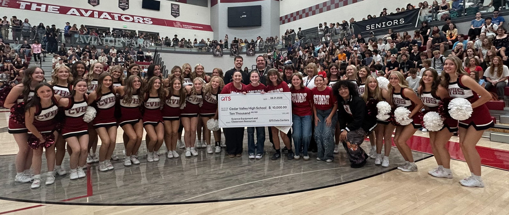 Cedar Valley High School students and  staff pose with large ceremonial check from QTS with QTS representatives