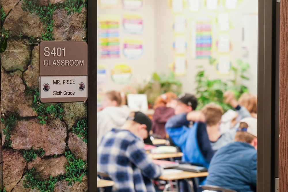 Open doorway to a sixth grade classroom with students learning inside.