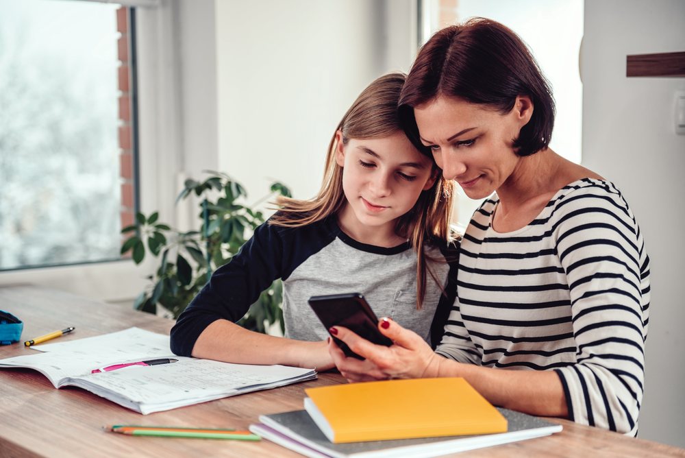 mom and daughter looking at a cell phone