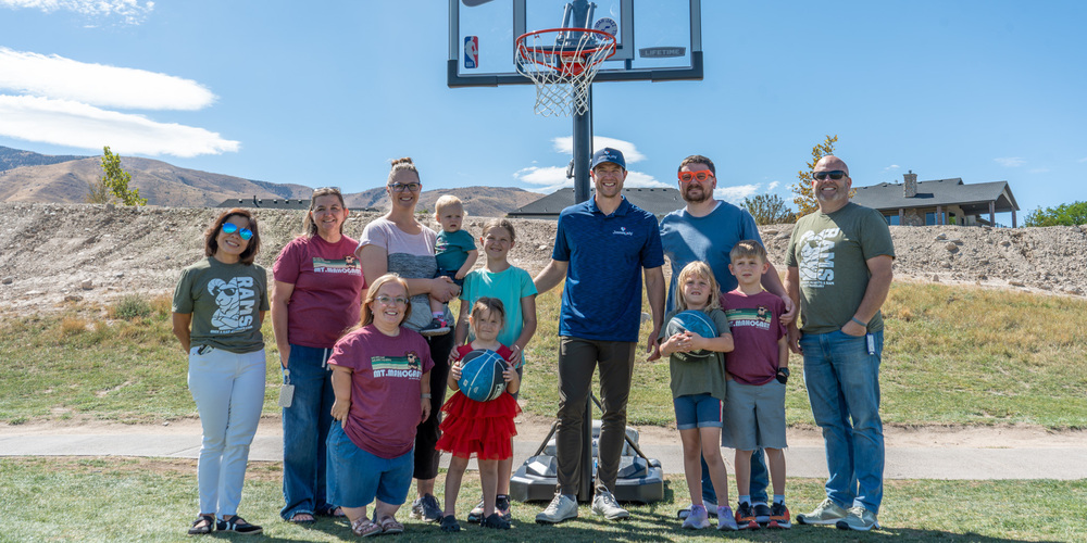 Jimmer Fredette Presenting a basketball hoop to a family from Mount Mahogany Elementary after a Jimmerosity golf tournament