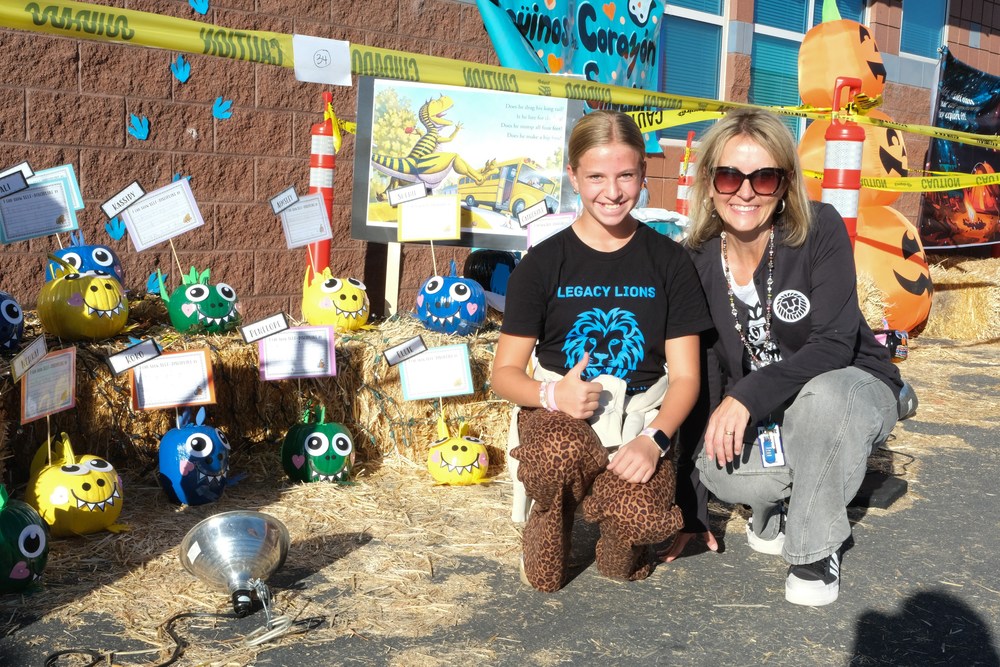 Jill Hanson with Reese Peterson in front of a pumpkin display