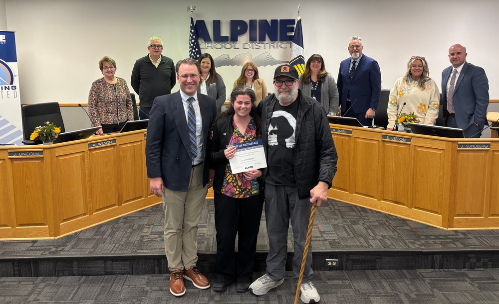 Jill and Kirk posing with school board at school board meeting.