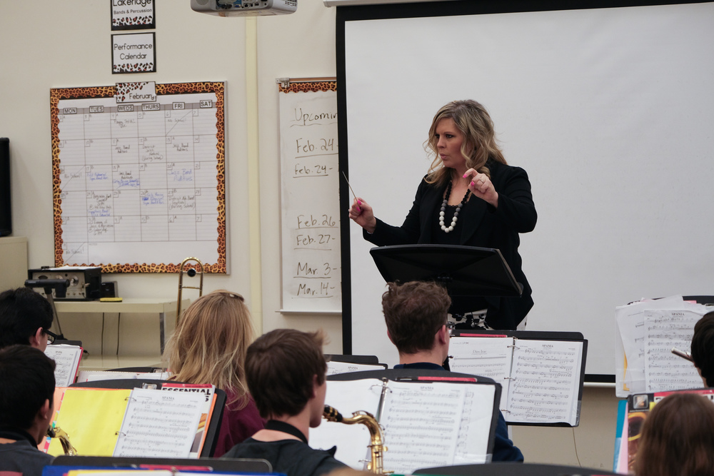 music teacher leading a jazz band class at the front of a classroom