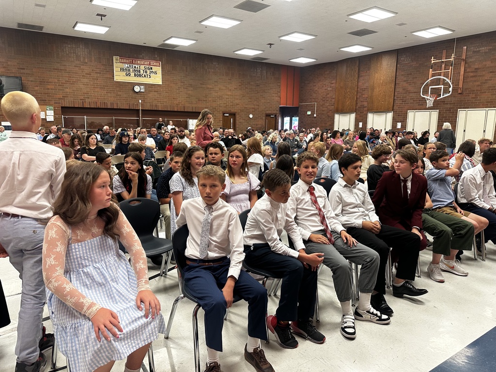 Students sitting on chairs in the lunchroom.