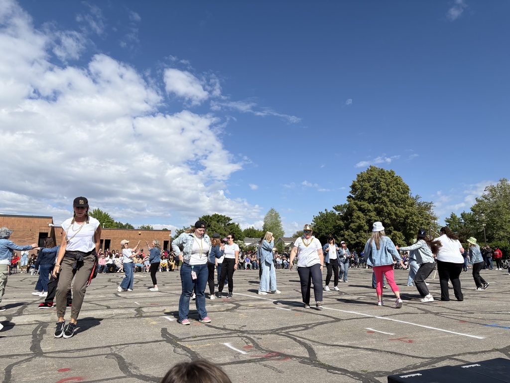 Adults standing on the blacktop getting ready to dance.
