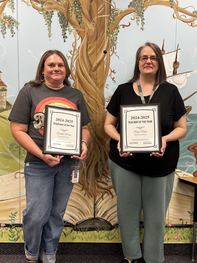 Two women standing, each holding a plaque.