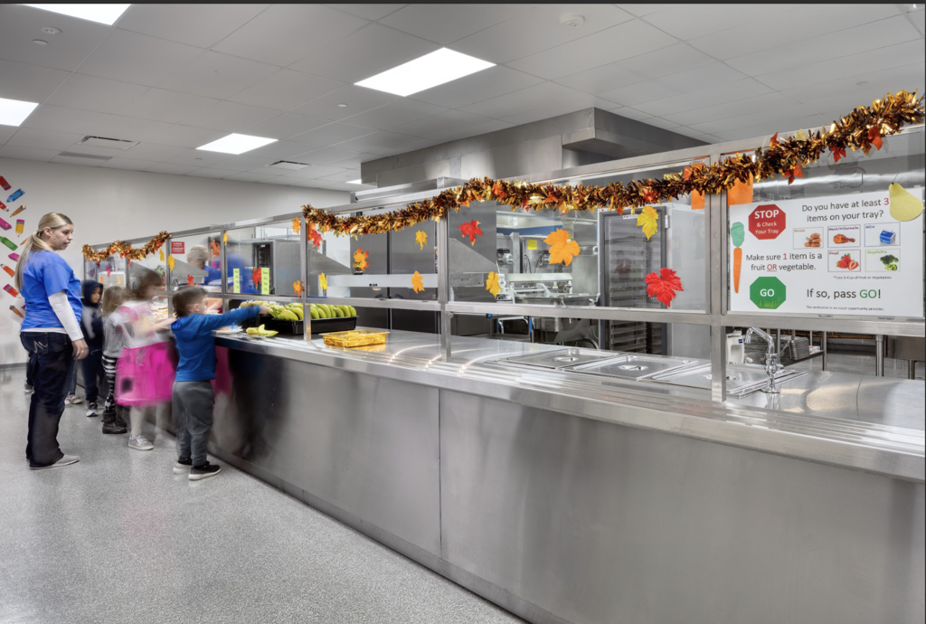Young students going through the school cafeteria lunch line.