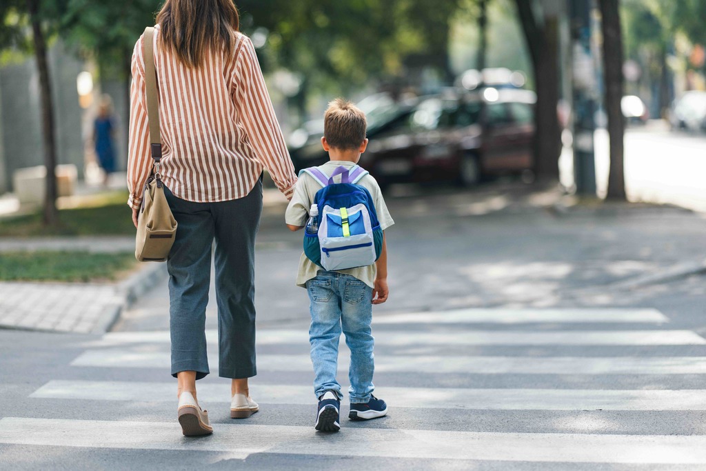 Parent walking student across street in crosswalk