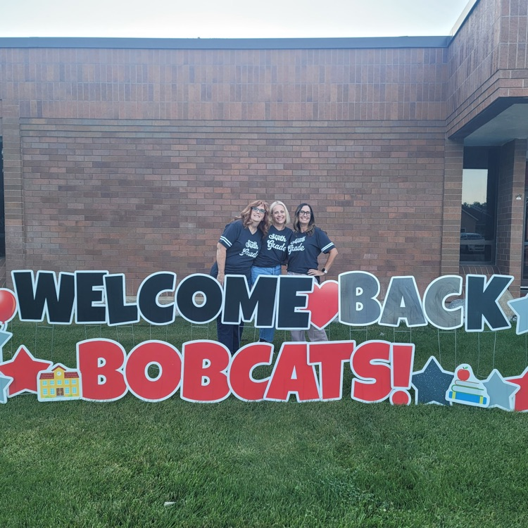 adults standing behind the welcome back sign