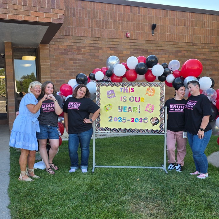 adults standing by the balloon arch