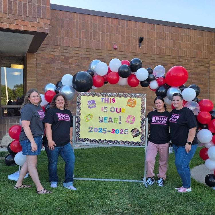 adults standing by the balloon arch