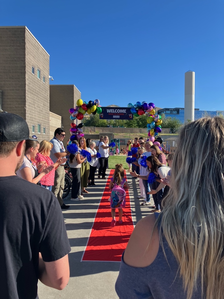picture of child walking down a red carpet with people cheering her on