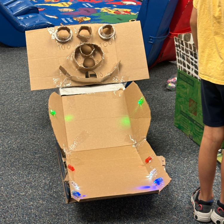 kids at play on homemade cardboard arcade game