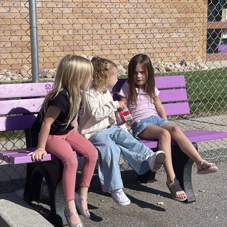 students sitting on the buddy bench at the Highland playground